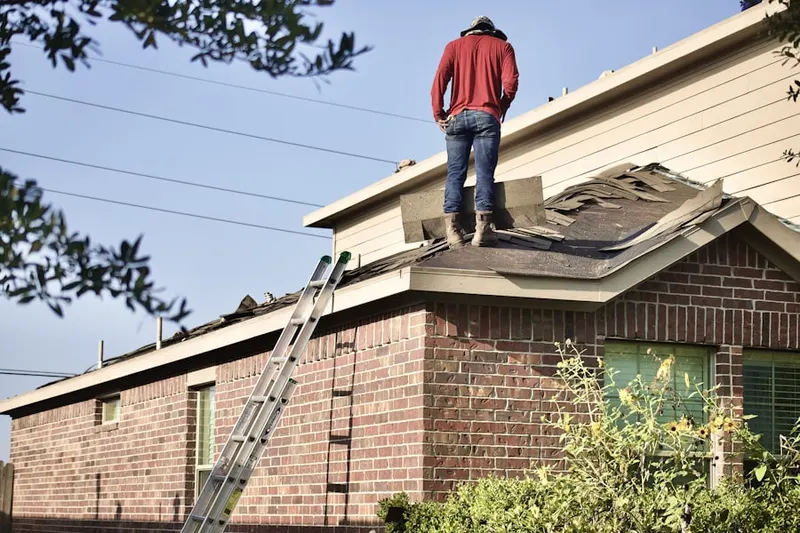 Professional roofer working on a residential roof in Central Village